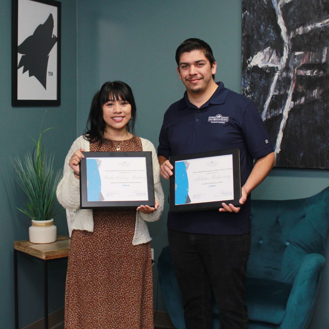 Photo of two advisors with award plaques